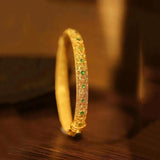 Brazalete en estilo de pulsera con piedras preciosas verdes doradas y patrones florales de estilo étnico