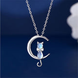 Collar con colgante en forma de media luna y un gato de piedra lunar