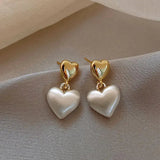 Pendientes de corazón con margaritas doradas