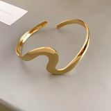 Pulsera abierta clásica con patrón de olas doradas
