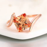 Anillo con piedra preciosa en naranja, en forma de pirámide, de oro rosa