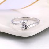 Anillo con barra curva de plata y diamante brillante en el centro